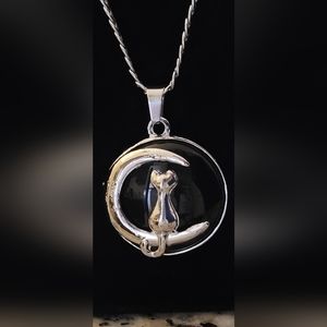 Cat sitting on a crescent moon with a black gemstone background pendant necklace